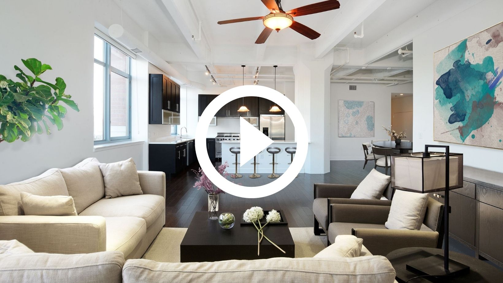 image of spacious open plan living room with white play button in the middle