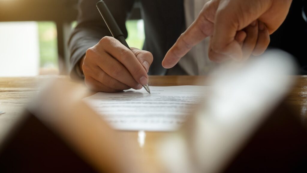 Man signing an agreement for a new house sale.