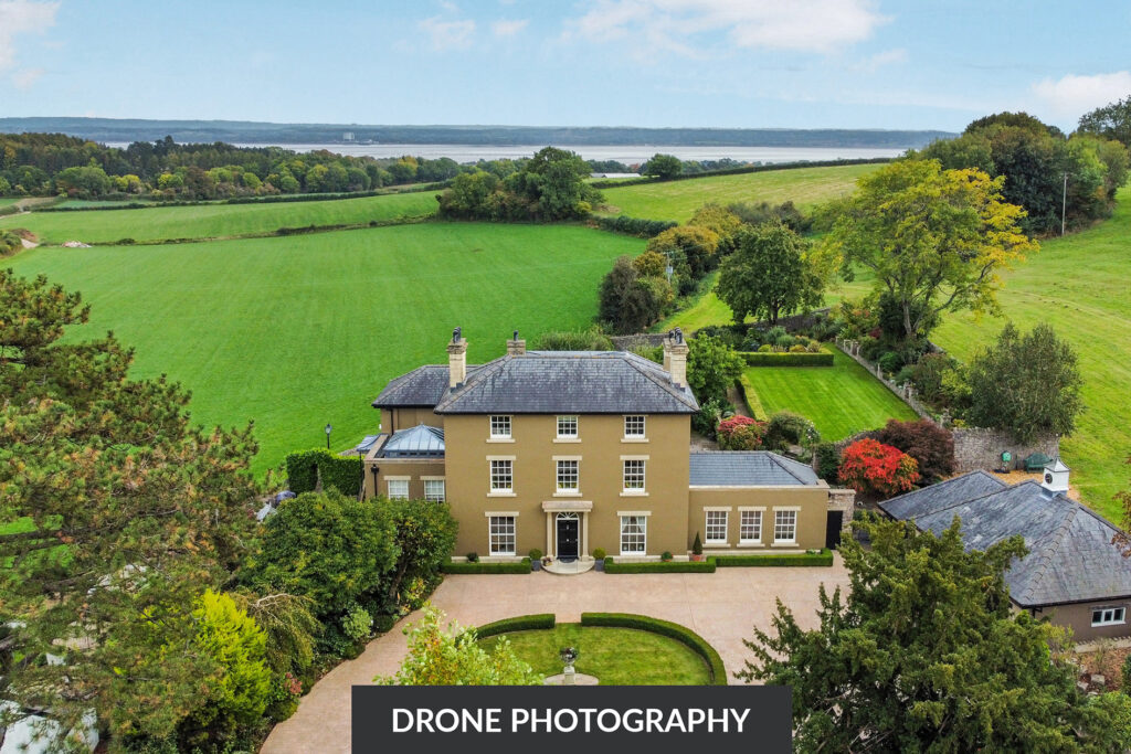 Drone shot of a large detached house with a field behind